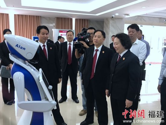 院长陈绍荣的介绍下察看了导诉机器人小法。