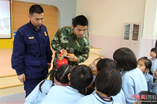 宣传员向师生介绍灭火器原理和使用方法。 上杭县消防大队供图