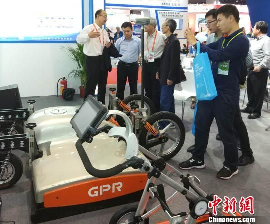  图为35所科技委主任焦晓亮（左1）在广州举行的展会上介绍“鹰眼”探地雷达产品。　35所/供图　摄