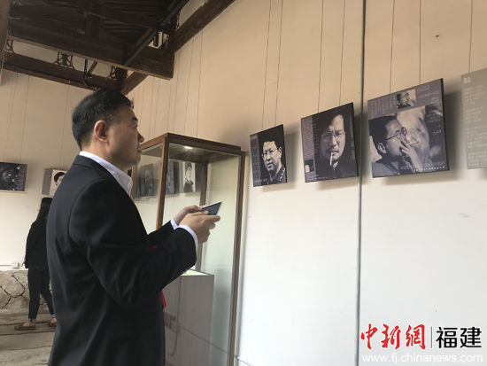 图为诗歌爱好者正在欣赏“中国诗歌的脸”全国知名诗人肖像及作品展。韦菊 摄