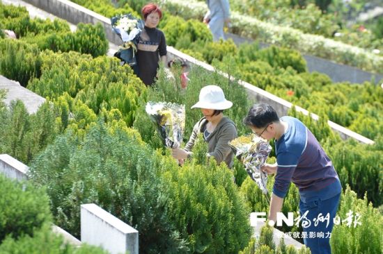 5日，记者在三山陵园发看到，祭扫者达都手捧鲜花。他们表示用鲜花代替爆竹来祭奠祖先、寄托哀思，更加绿色环保。 记者 池远 摄