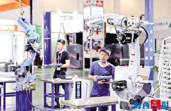 厦门智造展位，工作人员在调试工业机器人 。记者 陈理杰 摄