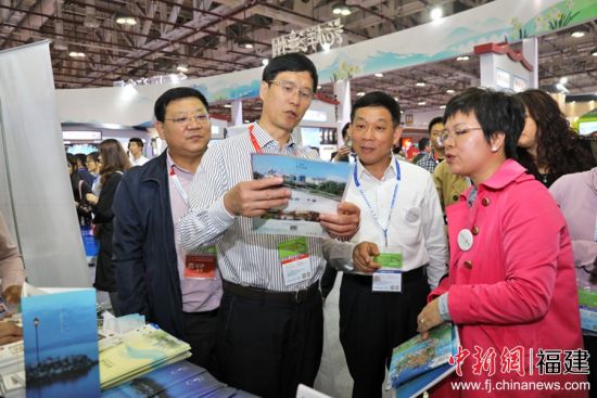 漳州市副市长兰万安（左二）莅临漳州开发区展位了解开发区旅游产品相关情况