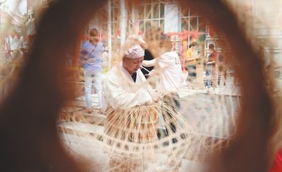 第十四届莆田艺博会上，手艺人在制作竹编工艺品。