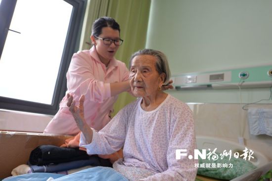 护理人员在照料百岁老人。