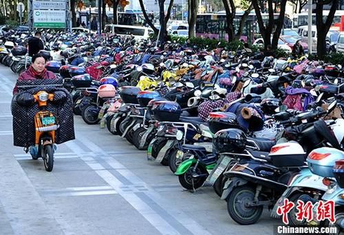 资料图片为：1月16日，福州市民从停车场骑电动车准备出行。 中新社记者 张斌 摄