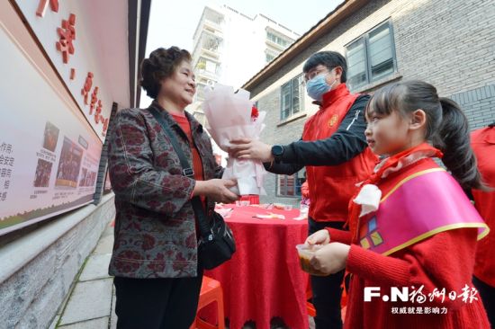 中山社区党建联盟单位志愿者为老人送上拗九粥和鲜花。记者 池远 摄