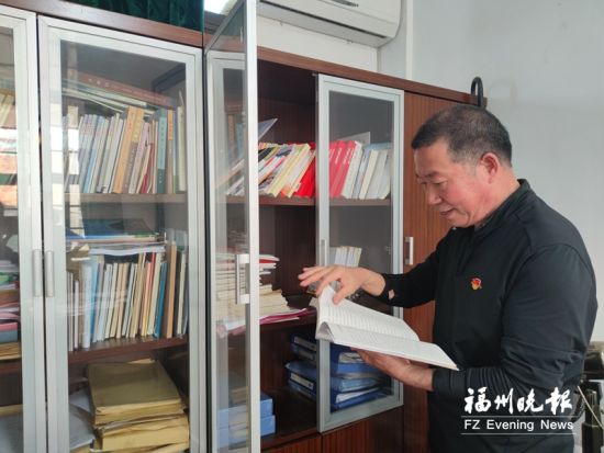 林金平查阅资料，为新一期节目做好准备工作。记者 冯雪珠 摄