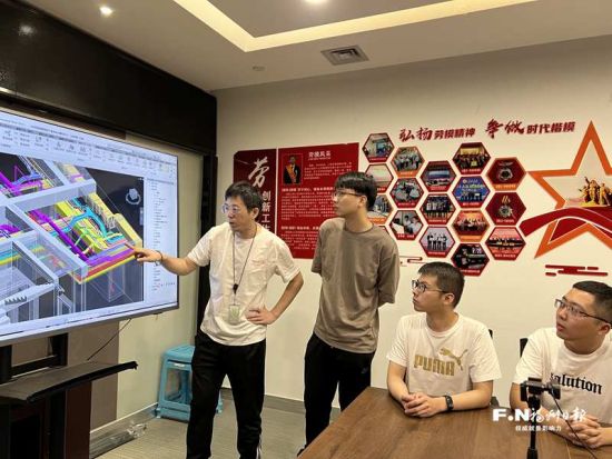 杨昆（左一）与在省赛获奖的3名劳模创新工作室成员探讨业务。 记者 李白蕾 摄