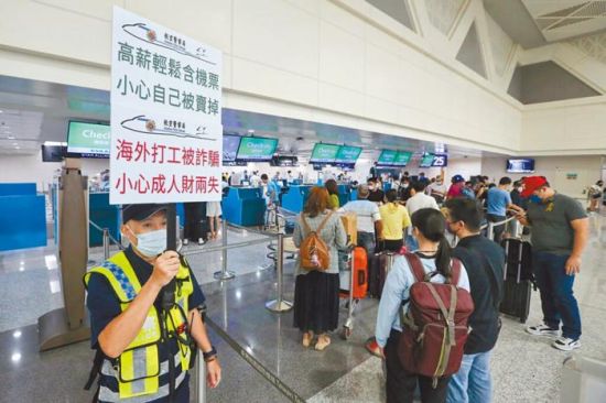 工作人员在机场举牌提醒民众提防被诈骗。图片来源：台湾中时新闻网