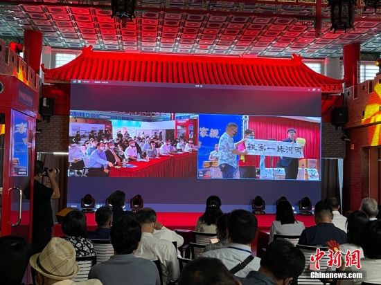 图为北京会场，画面中台湾同胞在展示书法作品。 中新社记者 朱贺 摄