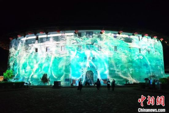 永定土楼景区夜间推出3D灯光秀、“天涯明月刀”沉浸式演艺剧场，让游客身临其境在现代声光电带来震撼感。　永定土楼景区供图