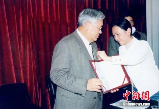 2004年3月客座教授聘任仪式上，曾永义先生(左)佩戴武汉大学校徽。郑传寅教授供图