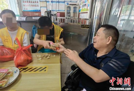 杜志文与两位残疾员工聊天。　吴剑　摄