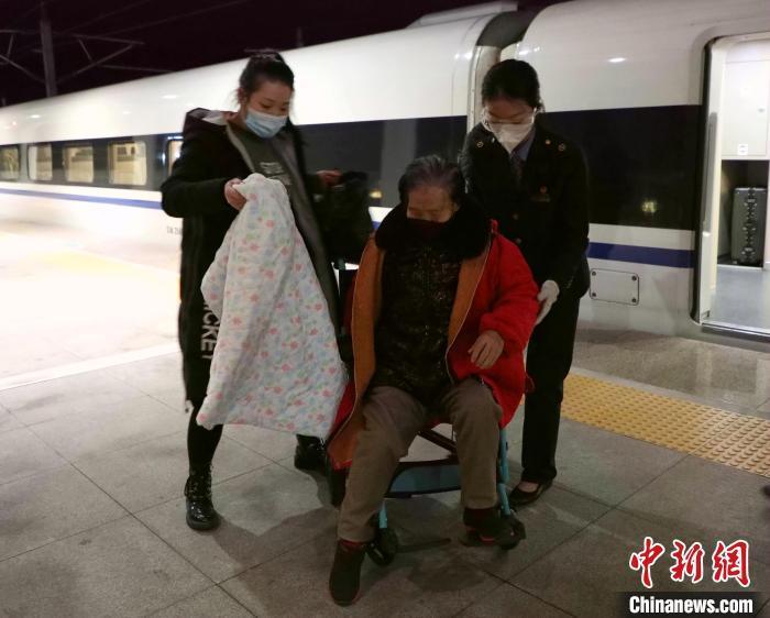 1月30日，在建甌西火車站站臺上，姐姐王雯萱(右)幫扶重點旅客下車�！±钜幻� 攝
