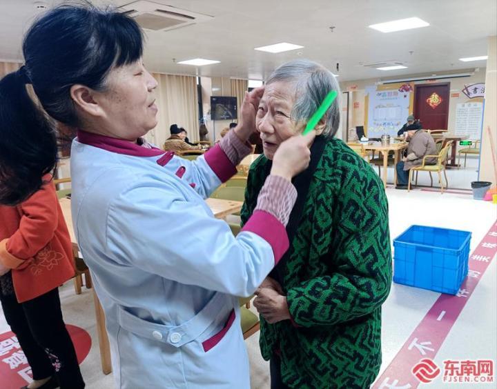 护理员叶岭妹正在给老人梳头，整理衣裳。东南网记者林先昌 摄