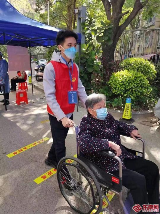 晋安区象园街道乐西社区志愿者为出行不便的老人推轮椅 东南网记者 陈楠 摄